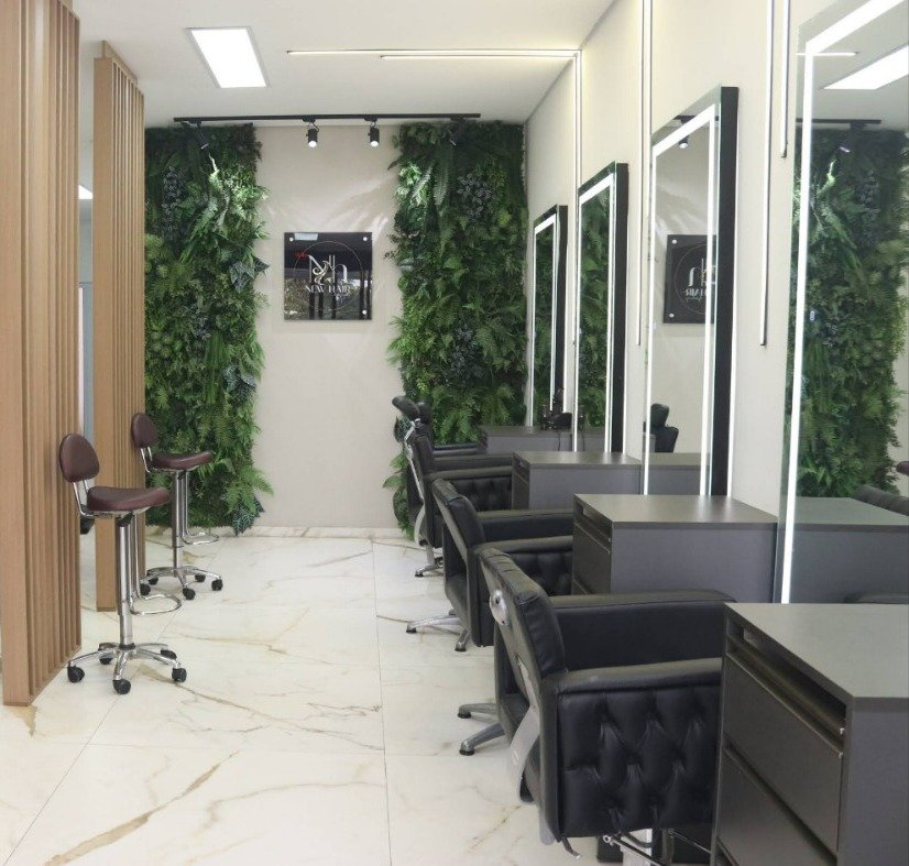 Interior minimalista do salão com mármore, detalhes dourados e cadeiras pretas